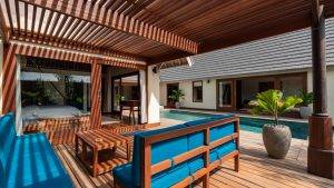 Timber terrace with wooden structure beside a private swimming pool in a tropical villa setting