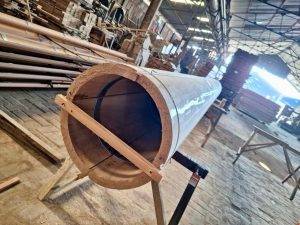 Skilled worker shaping hardwood components for villa structures